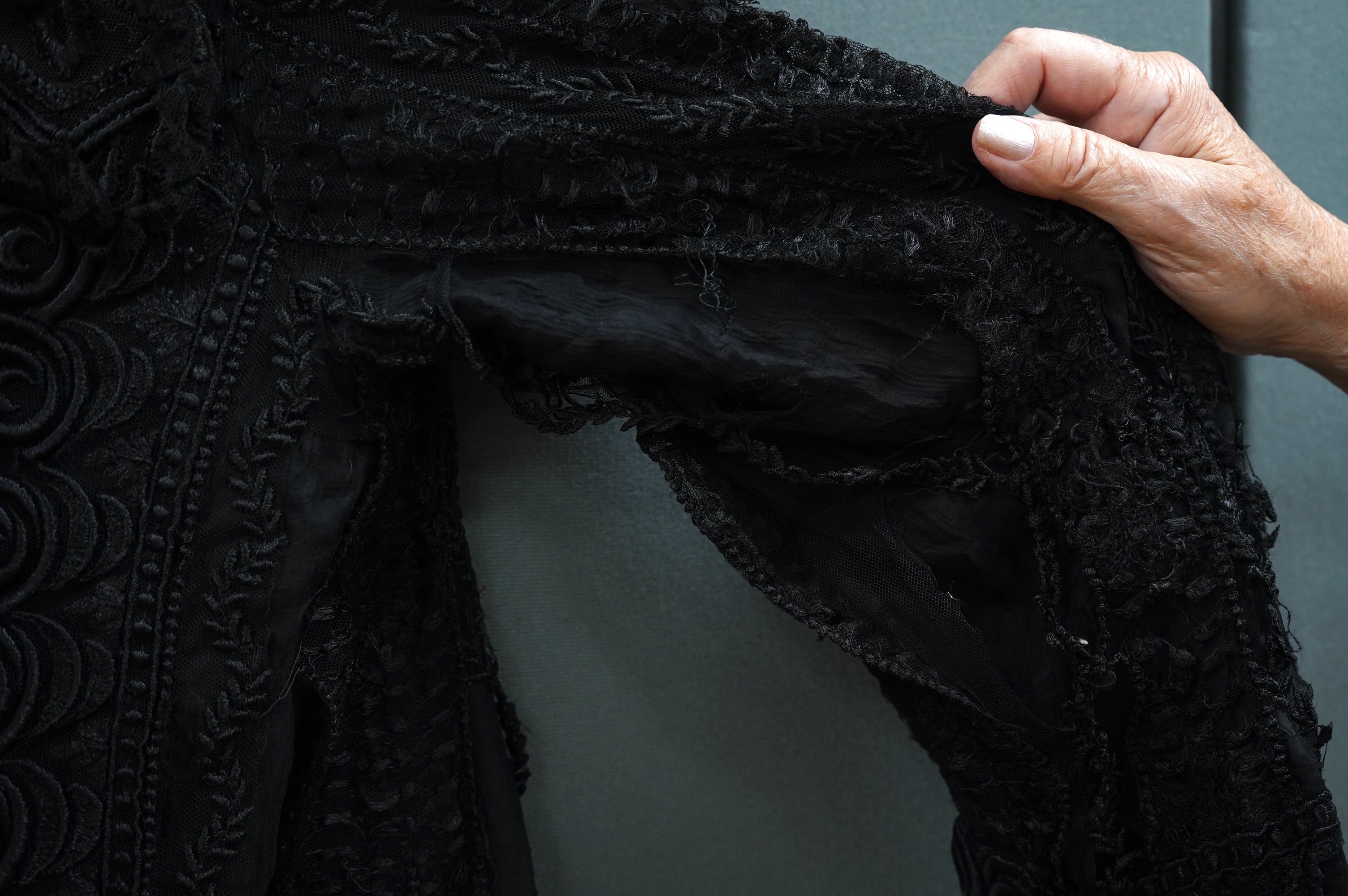 An Edwardian black chiffon and lace evening jacket with tassel decoration to the front and back, edged with tasselled fringing to the edge of sleeves and bottom, 85cm long from nape of neck at the back to bottom of tasse